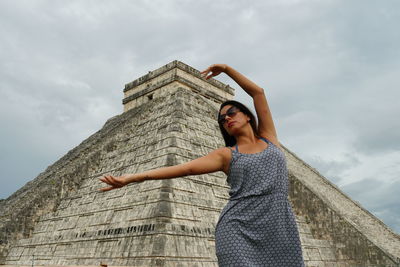 Low angle view of woman standing against the sky