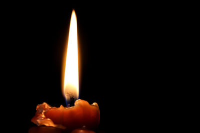 Close-up of burning candle in darkroom