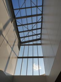 Low angle view of glass building against sky