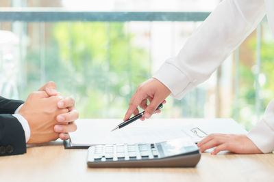 Cropped image of people with hands on table