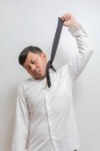 Young man standing against white background