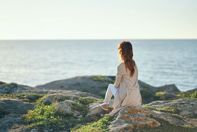 Rear view of woman looking at sea against sky