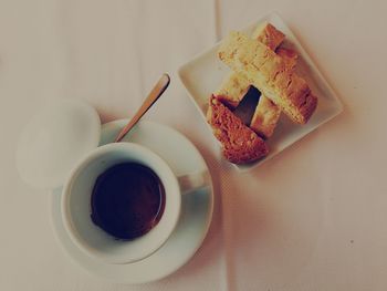 High angle view of coffee with bread served on table