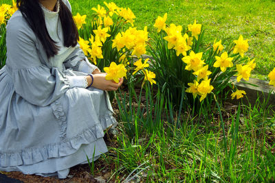 Young woman in vintage dress in flower garden
