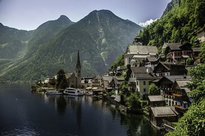 Lake and buildings in town against sky