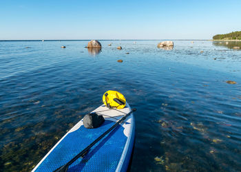 Rear view of man floating on sea against clear sky