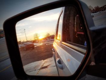 Reflection of sky on side-view mirror of car