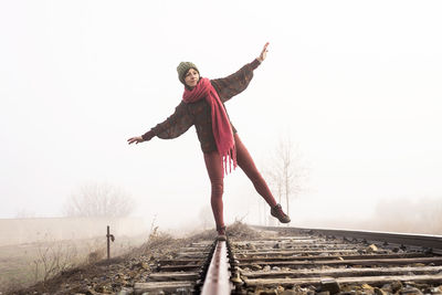 Front view of a girl balancing on train rail while walking