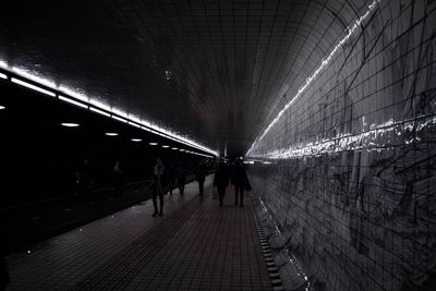 People walking on illuminated subway station
