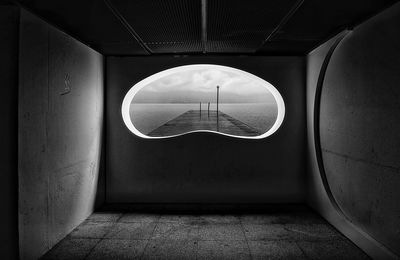 View through a concrete wall to a lake in heavy rain