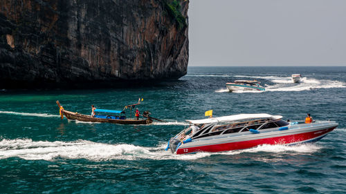 Boats sailing in sea against sky