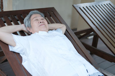 Senior woman relaxing on deck chair