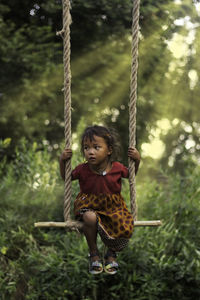 Low angle view of girl on swing