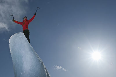 Woman climbinbg iceberg on the fjallsjoull glacier lagoon