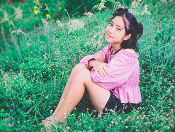 Portrait of girl sitting on grass in garden