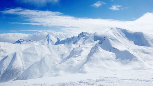 Scenic view of snow covered mountains against sky