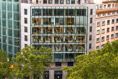 Office building with glass wall and view of working people at their desks