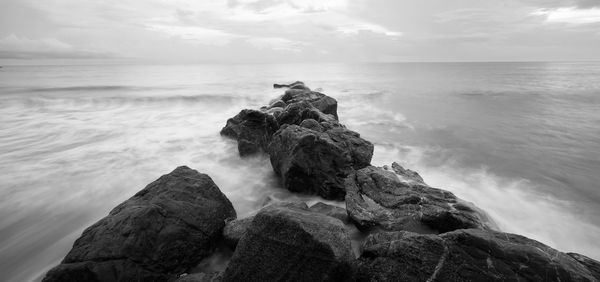 Rocks on sea shore against sky