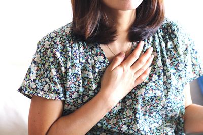 Midsection of woman standing against wall