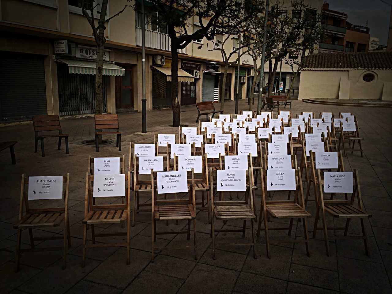 text, building exterior, built structure, western script, architecture, communication, city, non-western script, no people, empty, day, absence, outdoors, information, chair, information sign, street, capital letter, sunlight, residential building