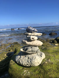 Stack of stones on beach against sky