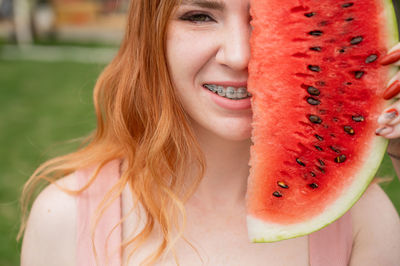 Close-up of portrait young woman holding yellow watermelon