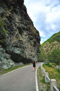 Rear view of man walking on mountain road