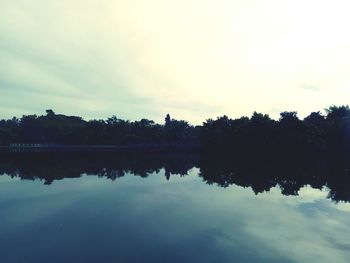 Reflection of trees in lake during sunset