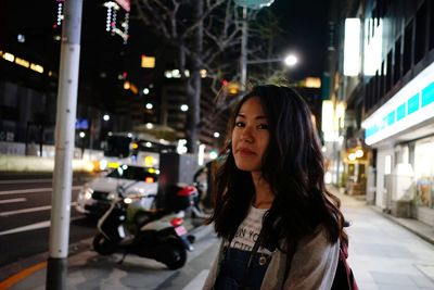 Woman standing in city at night