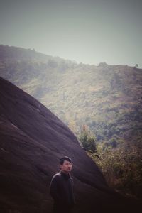 Man standing on mountain against sky