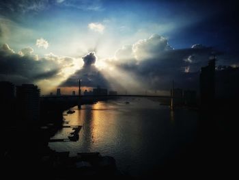 Bridge over river in city against sky