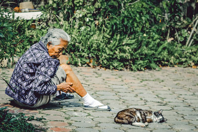 Man and cat relaxing by plants