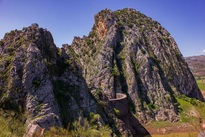 Low angle view of rock formation on mountain against sky