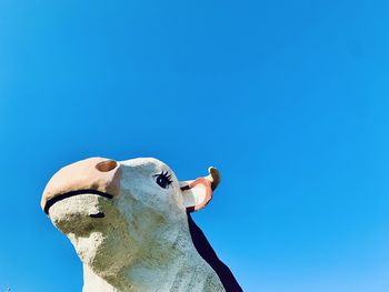 Low angle view of a bird against clear blue sky