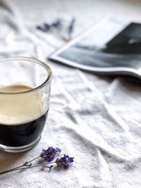 Close-up of drink by flower on fabric