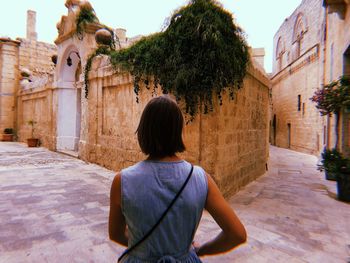 Rear view of woman looking at buildings in city