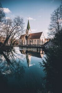 Building by lake against sky