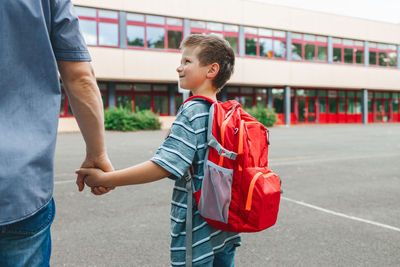 School concept. dad walks his son with a backpack on his back to school. parents take care