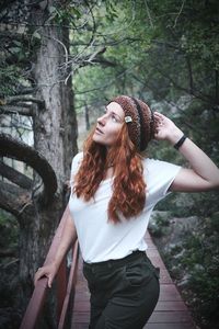 Full length of young woman standing in forest