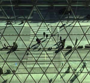 Low angle view of people on glass building