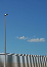 Low angle view of street light against blue sky