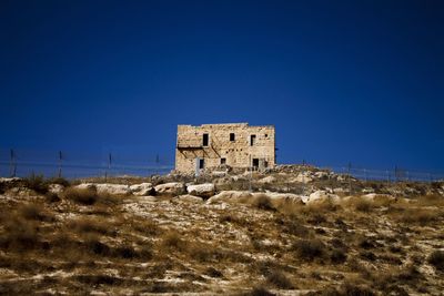 Low angle view of old building against clear blue sky