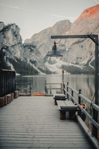 Pier in lake against snowcapped mountains