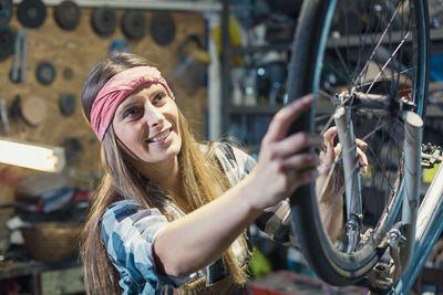 Portrait of smiling young woman with bicycle