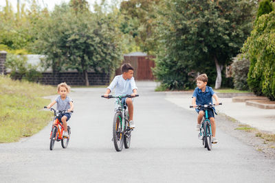 Rear view of people riding bicycle