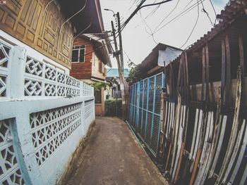 Footpath amidst buildings against sky