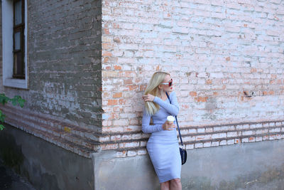 Beautiful woman standing against wall