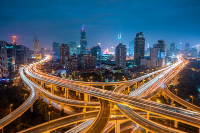 High angle view of illuminated highway amidst buildings in city at night