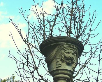 Low angle view of statue against bare tree