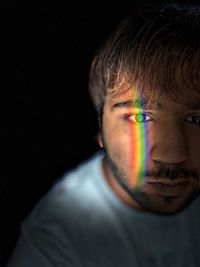 Portrait of young man against black background